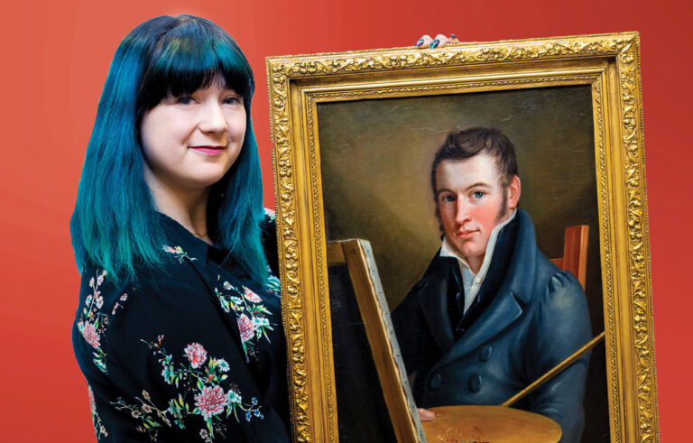 Someone with blue hair and bangs holding up a gold framed painting of Francis Martin’s self-portrait