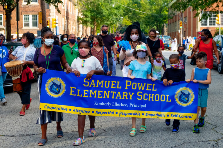 students holding a' samuel powel elementary school' banner