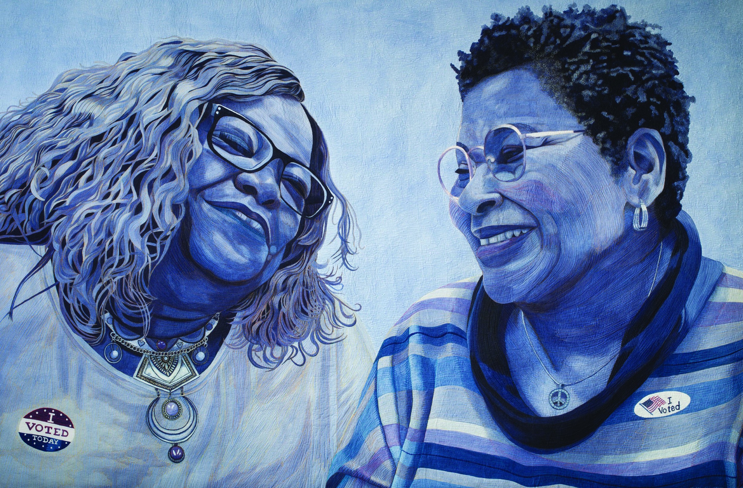 A quilted artwork, painted in shades of blue, depicting two Black women smiling at each other. Both women are wearing 'I Voted' stickers.