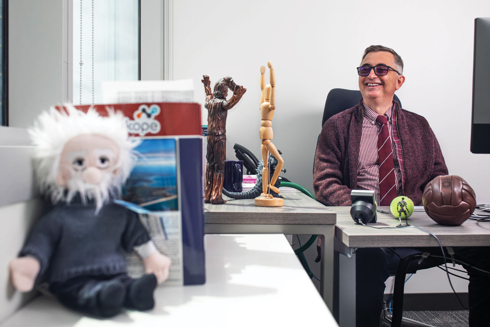 founSpiros Mancoridis at his desk with an Einstein doll