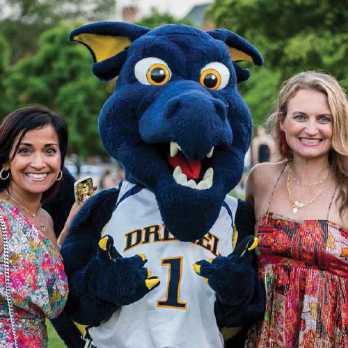 Two alumni with Drexel mascot Mario the Dragon