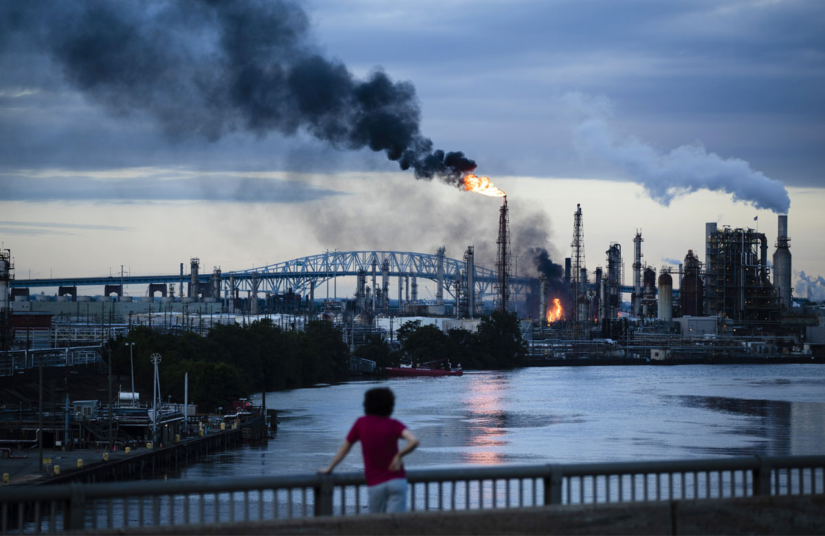 person watching a fire at a refinery factory