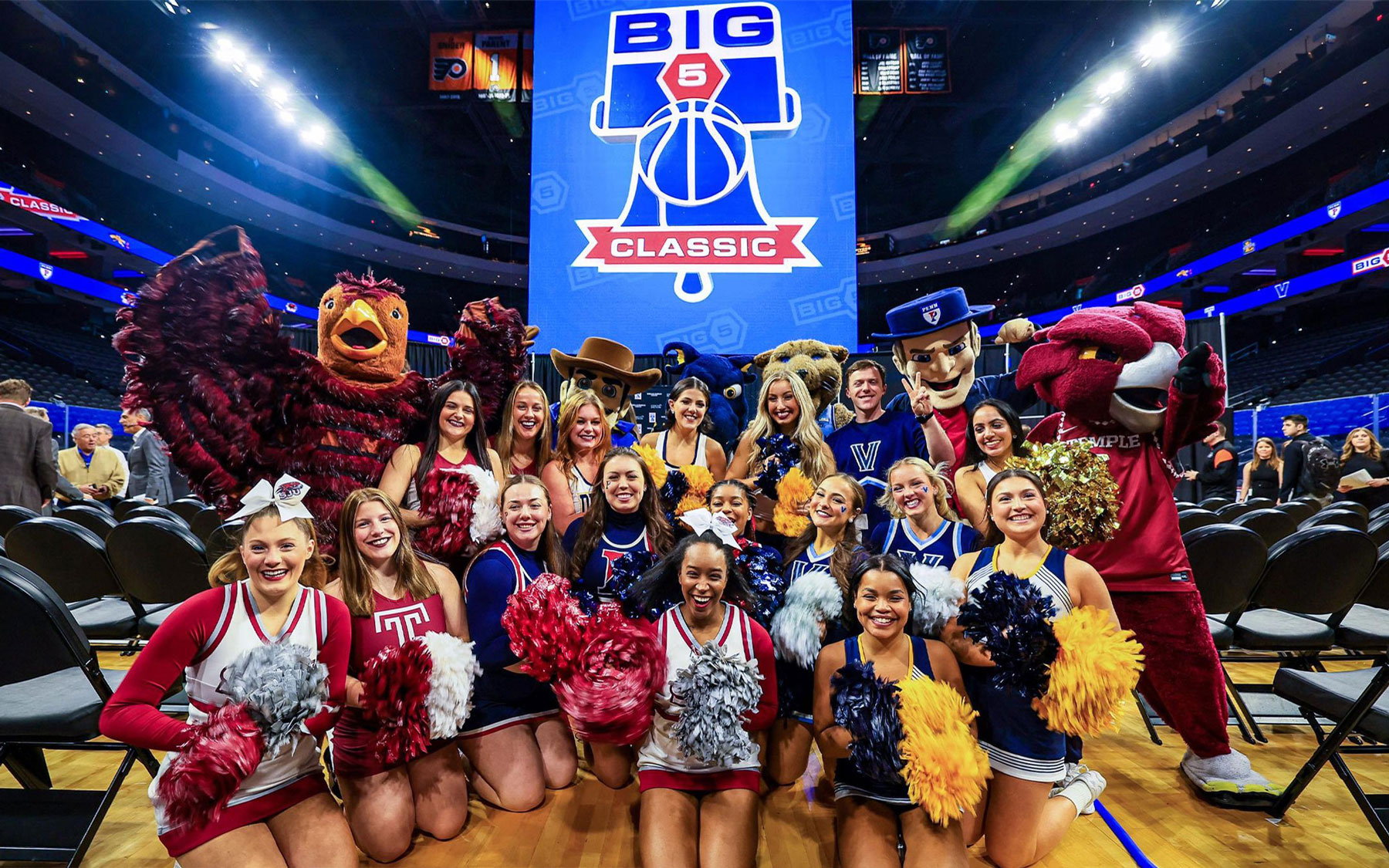 cheerleaders and mascots pose in a stadium